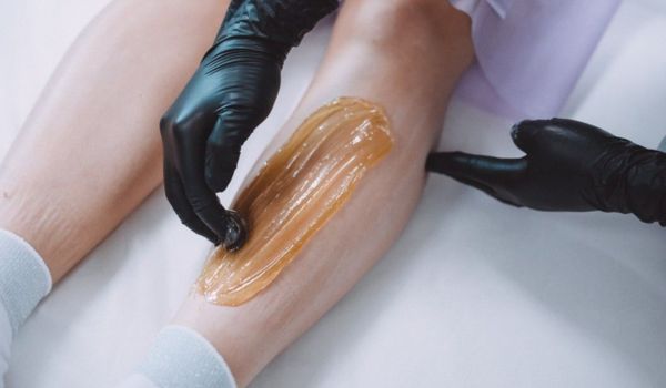Professional leg waxing procedure using sugar paste at Sugar Fairy